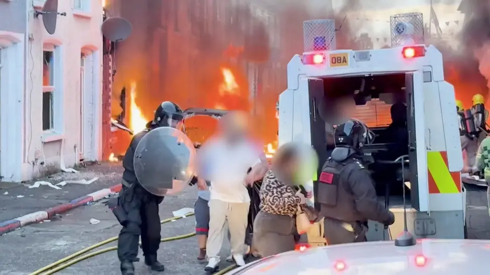 Belfast Residents Flee Burning Homes After Knife Attack Prompts Disorder